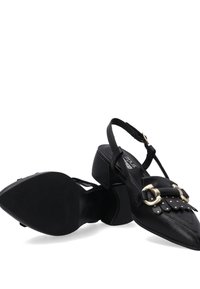 Černé kožené slingback boty s špičatou špičkou, ozdobené dekorativními nýty a akcentem přezky. Nízký podpatek s texturovanou podrážkou.