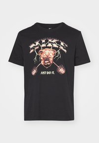 Sort bomulds t-shirt med et grafisk motiv af en bulldog med vægte, omkranset af lyn. Teksten lyder "NIKE JUST DO IT." Enkel design med rund hals.