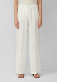 Pantalons blancs à jambes larges en tissu texturé. Comprend une fermeture à boutons sur le devant, des plis et un ourlet droit qui tombe aux chevilles.