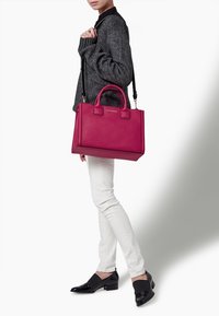 Magenta lædertaske med top håndtag og en aftagelig skulderrem. Glat tekstur, rektangulær form og minimal branding.
