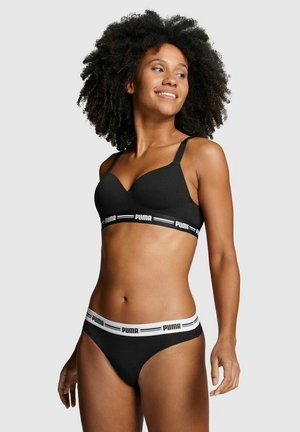 Black bra and matching thong with a soft texture. Bra features a v-shaped design and adjustable straps; waistband displays a logo band.