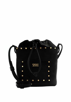 Sac seau noir DKNY Jeans orné de clous dorés sur la poche avant et le bord supérieur, avec une fermeture à cordon et une bandoulière ajustable.