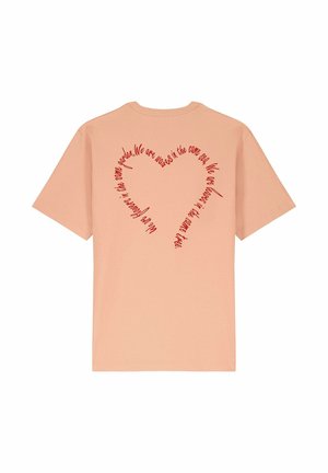 Peach-colored cotton t-shirt with a round neck. Back features red text arranged in a heart shape, expressing an inclusive message.