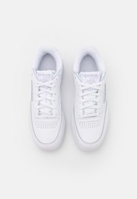 Vita lädersneakers med rund tå och perforerade detaljer. Har vita snören och en vadderad krage med Reebok-logotyp på tungan.