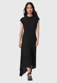 Černé šaty po kolena s krátkými rukávy ve tvaru křídla, kulatým výstřihem a asymetrickým spodním lemem, vyrobené z lehké a hladké látky.