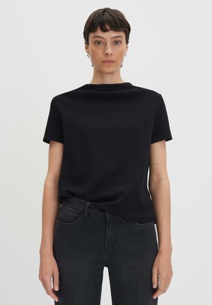 T-shirt nera a maniche corte con scollo rotondo. Il tessuto ha una sottile trama. Abbinato a jeans scuri, creando un look monocromatico.