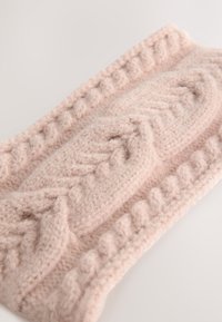 Bentiță tricotată din lână moale, roz deschis. Prezintă modele texturate în relief și margini cu nervuri. Formă dreptunghiulară cu un aspect gros și confortabil.