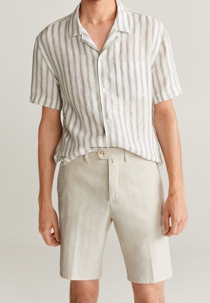 Chemise à manches courtes avec des rayures verticales vertes et blanches, associée à un short beige clair doté d'une poche avant et d'une fermeture à bouton.