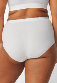 Mutande bianche in cotone a vita alta con una cintura ondulata e una texture liscia, prive di motivi visibili o accessori.