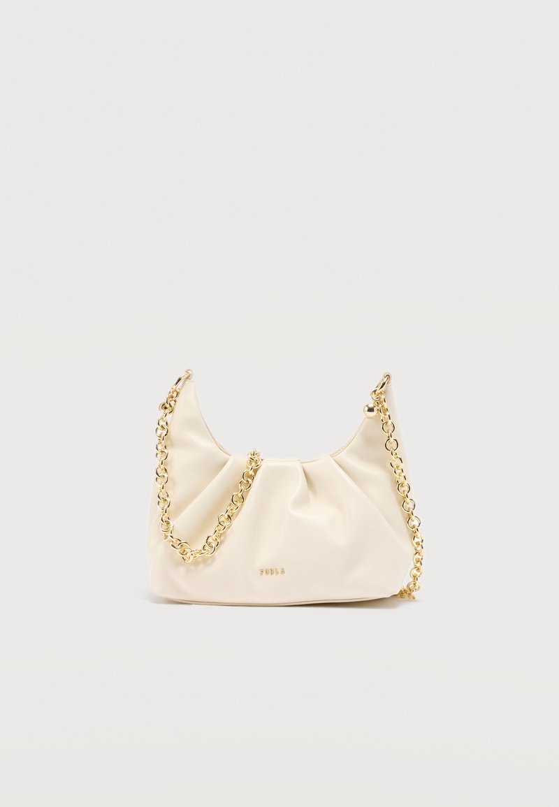 Τσάντα χειρός από απαλό δέρμα σε κρεμ χρώμα με χρυσή αλυσίδα και μικρό χρυσό λογότυπο μπροστά, τοποθετημένη σε απλό φωτεινό φόντο.