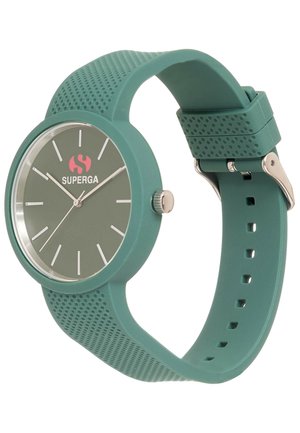 Montre en silicone verte avec un cadran rond, design minimaliste, index des heures en argent et un logo à 12 heures, maintenue par une boucle en métal.