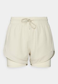 Pantalones cortos deportivos beige con cintura ajustable, que cuentan con una capa exterior suave y una capa interior de malla texturizada para una mejor transpirabilidad.