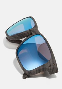 Ochelari de soare cu o ramă din lemn închis, lentile mari pătrate și lentile reflectorizante de culoare albastră. Include mici accente metalice lângă balamale.