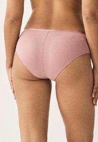 Lyserød ribbet bikini bund med lav talje, der har en glat tekstur og enkle sømme, vist fra en bagfra perspektiv.