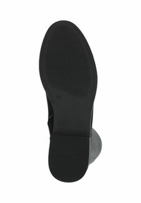 Suela de bota negra con patrón de agarre texturizado y bordes suaves, con un tacón ligeramente elevado y un diseño de punta redondeada.