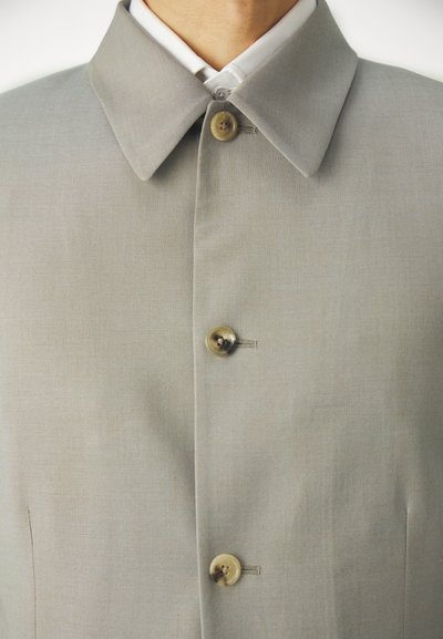 Gray tailored coat with a structured collar, featuring two brown buttons and a smooth textured fabric, highlighting a minimalist design.