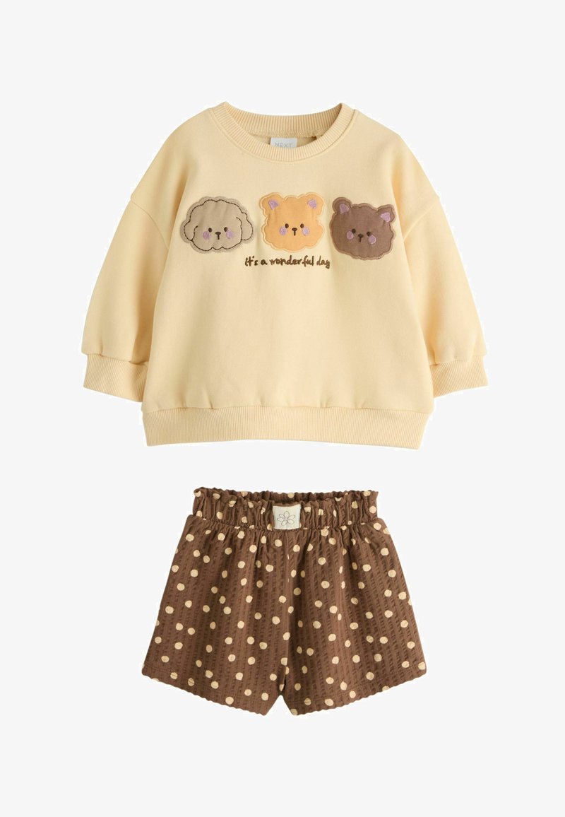 Sudadera color crema para niño pequeño con tres caras de animales y texto "It's a wonderful day", combinada con pantalones cortos marrones con lunares y cintura elástica.