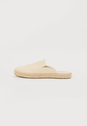 Beżowa espadryla na wsuwkę z tkanym tekstylnym cholewką, sznurowaną podeszwą i płaskim designem. Posiada szerokie otwarcie ułatwiające wsunięcie stopy.