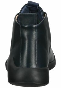 Bottine en cuir bleu foncé avec une finition lisse, bout rond et semelle en caoutchouc noire. Dispose d'une languette à l'arrière pour un enfilage facile.