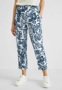 Kalhoty z bavlněné směsi s modro-bílým vzorem listů, s elastickým pasem, bočními kapsami a zkrácenou délkou. Spárováno s bílými teniskami.