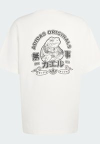 Λευκό βαμβακερό μπλουζάκι με μαύρο γραφικό σχέδιο ενός βατράχου με ρούχα, με το κείμενο «ADIDAS ORIGINALS» και κυκλικές διακοσμήσεις.