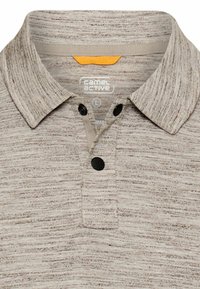 Beige meleret polo-shirt med tre sorte knapper og en opfoldet krave, mærket "camel active" indeni halsudskæringen.