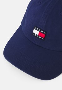 Căciulă de baseball navy din twill de bumbac, cu un patch dreptunghiular brodat pe care scrie "TOMMY JEANS", având accente în roșu, alb și albastru.
