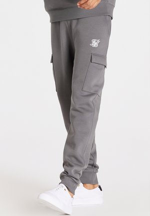 Graue Sweatpants mit elastischen Bündchen und Cargo-Taschen, ausgestattet mit einem kleinen weißen Logo. Hergestellt aus weichem Stoff, entworfen für Komfort und Funktionalität.