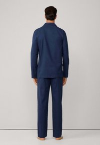 Conjunto de pijama azul marino con camisa de manga larga y pantalones rectos, fabricado en un tejido suave y con un collar clásico y un ajuste relajado.