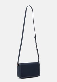 Bolso bandolera azul marino con forma rectangular plana, material de cuero suave, correa ajustable y sutiles acentos en dorado.