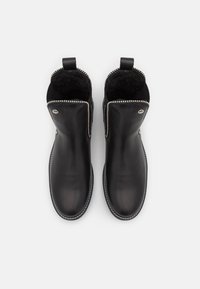 Svarta läderankelboots med ett mjukt inre, dragkedjestängning och dekorativ silverpärlstygn längs översidan. Slen textur, rund tå.