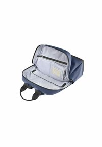 Zaino navy con un materiale esterno testurizzato, caratterizzato da una fodera interna a pois, un compartimento con zip e due manici neri.