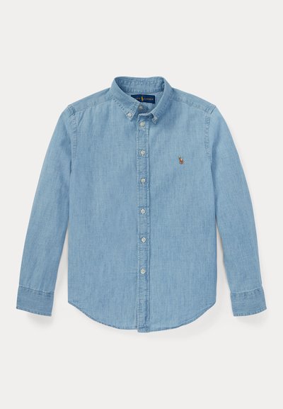 Lyseblå denimskjorte med lange ermer, knappestolpekrage og et lite brodert logo på venstre bryst. Har en avslappet passform.