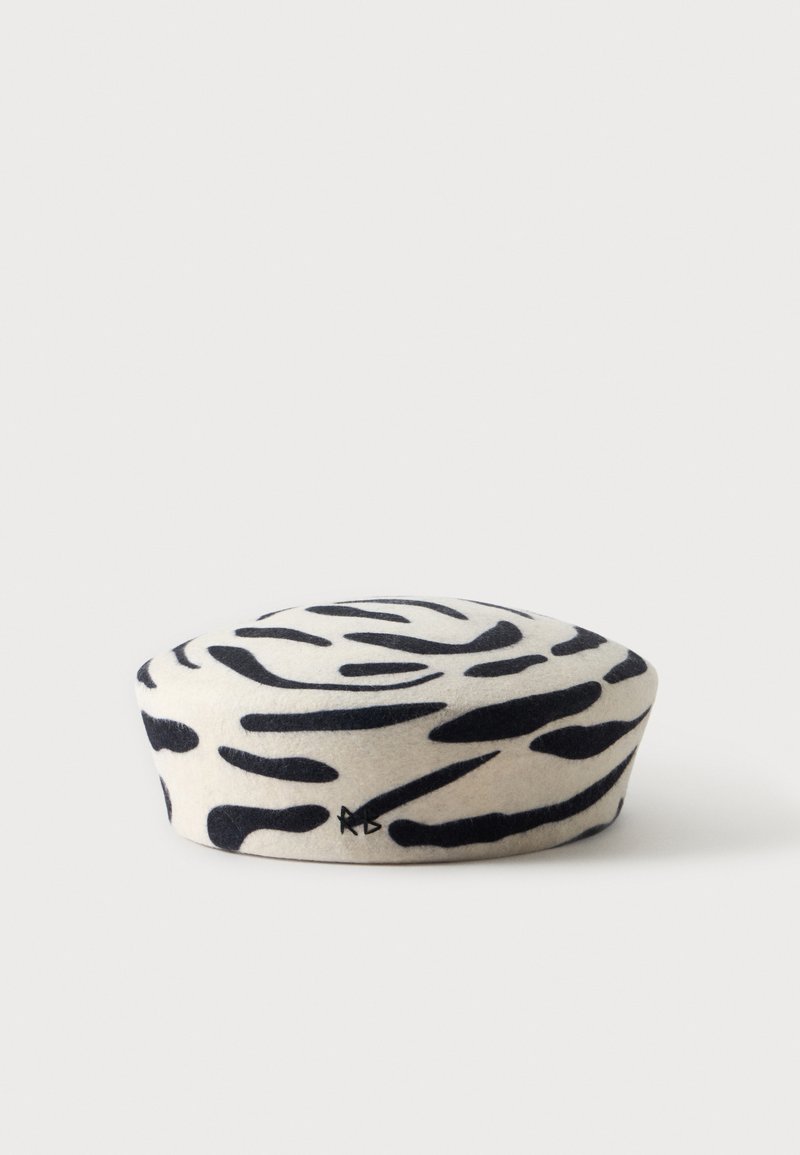 Béret blanc avec motif abstrait de rayures zèbre noires et petit logo noir brodé sur le côté.