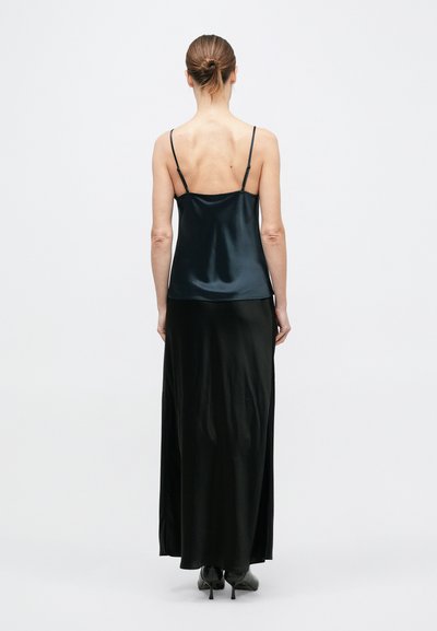 Szatén, sötétkék, vékony pántos kámzsa, melyet egy légies fekete maxi szoknyával párosítanak, sima textúrával és laza szabással.