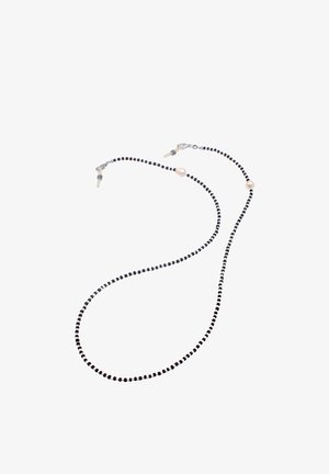 Perlekæde med sorte, hvide og beige runde perler, som har en glat overflade og to distinkte perleakcenter nær enderne.