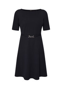 Robe noire mi-longue jusqu'aux genoux avec des manches courtes et une ceinture fine ornée d'une boucle chaîne argentée à la taille.