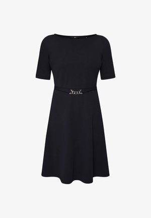 Sort knælang kjole med korte ærmer og et slankt bælte med spænde i sølvkæde ved taljen.