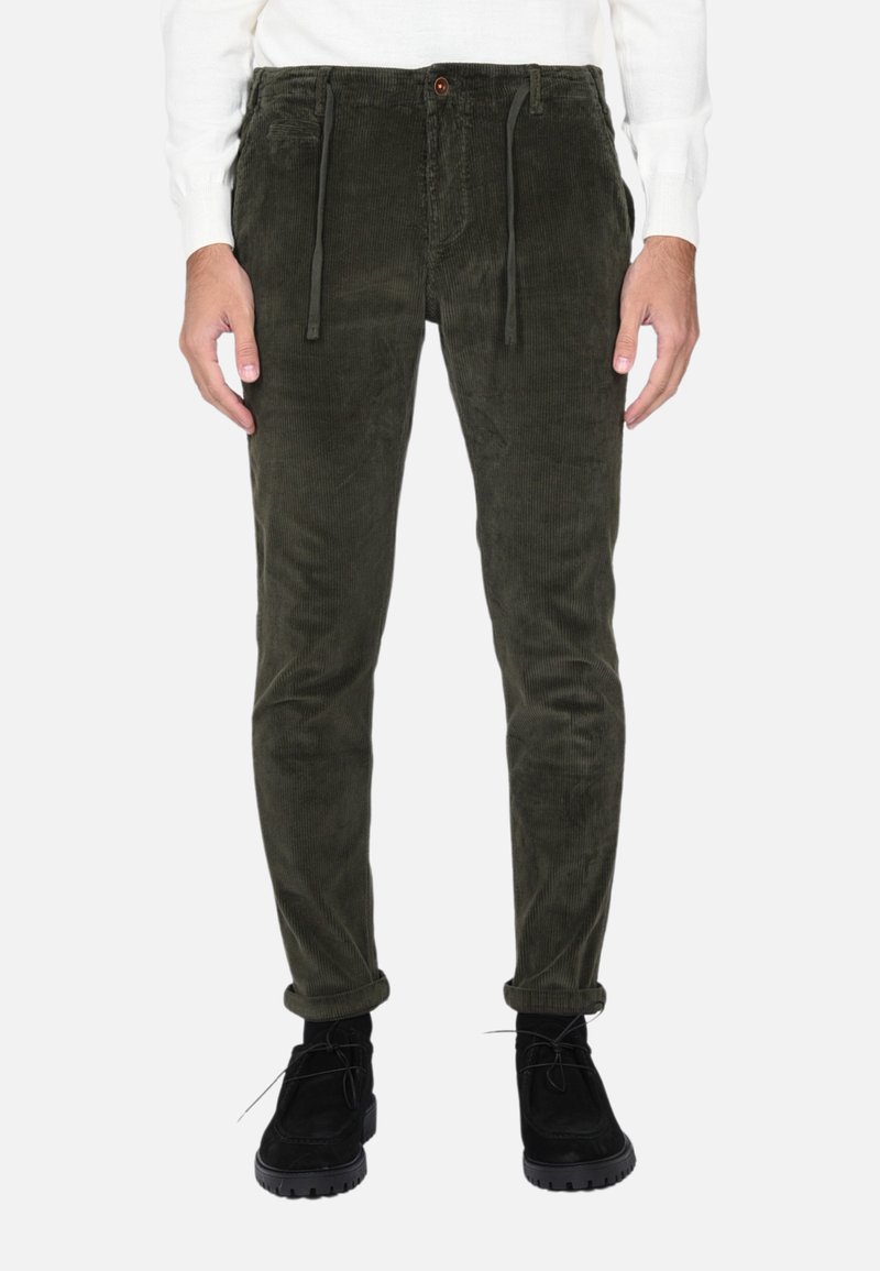 Pantaloni in velluto a coste di colore verde scuro, con vita elasticizzata e coulisse, tasche frontali e vestibilità slim. Orli arrotolati e tessuto testurizzato.