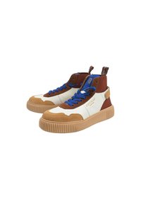Baskets montantes brunes et blanches avec des lacets bleus et une semelle texturée. Accentué d'une suède beige et dispose d'une boucle au niveau du talon.