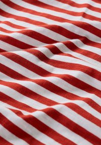 Tela de rayas rojas y blancas, de textura suave, con rayas horizontales uniformes de distintos grosores, creando una apariencia ondulada.