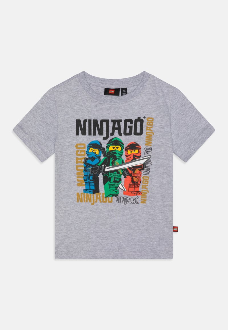 Graues T-Shirt mit kurzen Ärmeln und bunten LEGO Ninjago-Figuren in Blau, Grün und Rot, die Schwerter halten, sowie wiederholtem "NINJAGO"-Schriftzug.