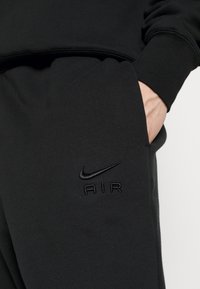 Must be Nike mustris, mille tekstuuri ja känguru taskuga, millel on esiküljel embosseeritud logo, kus on kirjutatud "AIR".