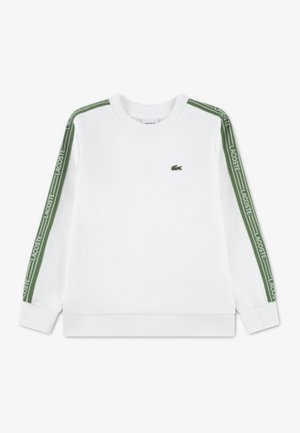 Felpa bianca con maniche lunghe, con il logo Lacoste verde lungo le spalle. Classico collo a girocollo e polsini a costine.