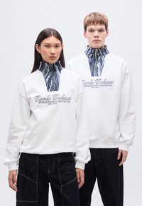 Λευκό φούτερ με ψηλό γιακά, που διαθέτει διακοσμητική μπλε και λευκή λωρίδα στον λαιμό. Κεντημένο λογότυπο στο στήθος. Σκούρο μπλε παντελόνι.