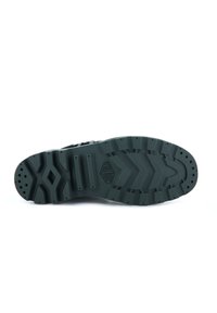 Sole di sneaker in gomma nera con un motivo di battistrada strutturato, dotato di vari solchi e tagli per una migliore aderenza. Design con punta rotonda, materiale resistente.