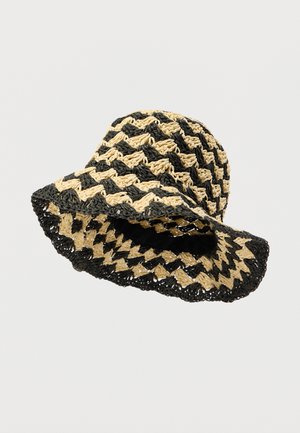Svart og beige vevd stråbøttehatt med chevronmønster, med bred brem og åpen veving for ventilasjon.
