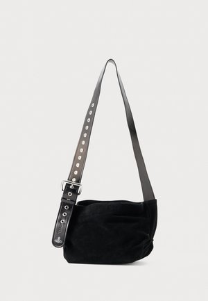 Black suede shoulder bag with wide adjustable leather strap featuring metal eyelets and buckle, displayed against white background.