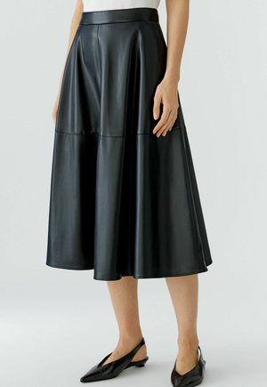 Schwarzer Leder-Midi-Rock mit tailliertem Bund und ausgestelltem Design, ausgestattet mit glatter Textur und Nahtdetails, kombiniert mit schwarzen Slingback-Schuhen.