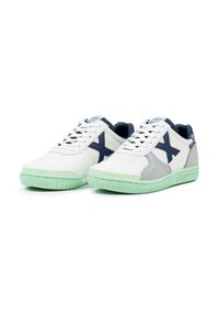 Zapatillas deportivas blancas y grises con una suela de goma verde menta, parte superior de malla y acentos en azul marino. Presentan cierre con cordones y diseño perforado.
